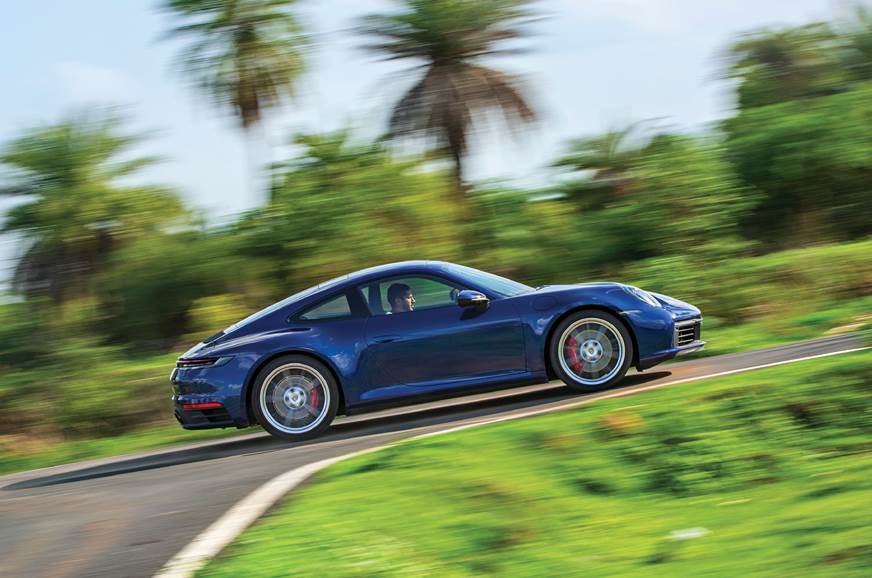 Silver porsche 911 parked on black asphalt road during night time