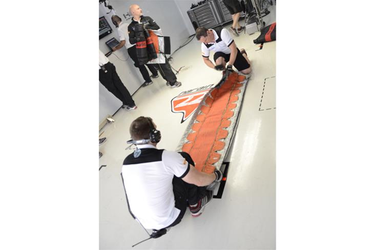HRT F1 team mechanics wrap the tyre blankets away.