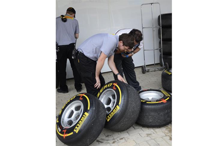 A Pirelli engineer inspects the soft tyres after the free practice session.