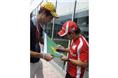Massa signs a Brazilian flag for a fan.