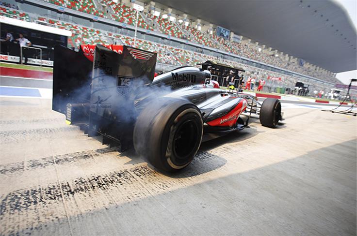 Jenson Button lays rubber in his pitbox during practice.