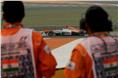 Marshals look on as a Force India VJM06 passes by.