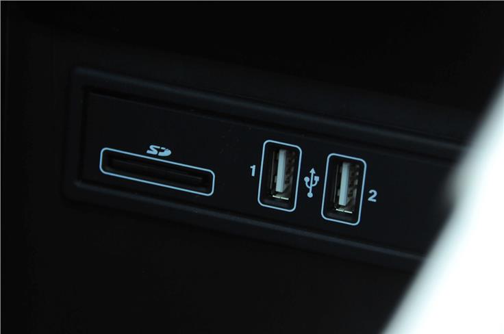 Centre armrest opens to reveal storage compartment with SD card reader and USB ports.