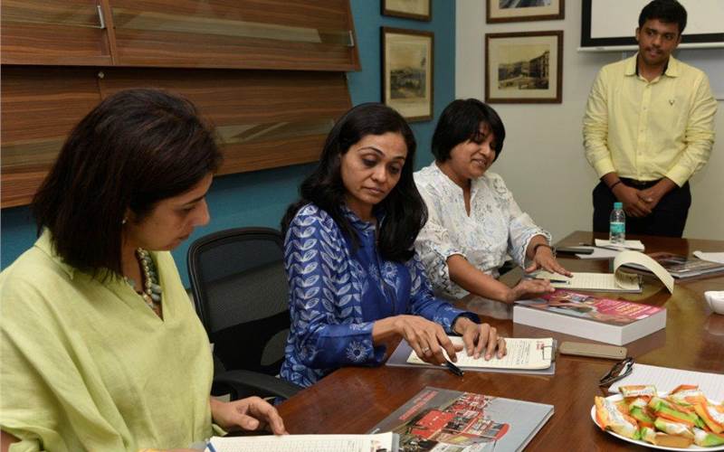 (l-r) Geetanjali Bhattacharji of Spatial Access and Naju Hirani of Marg Foundation discussing a book cover with Amruta Nemivant of Max Mueller Bhavan