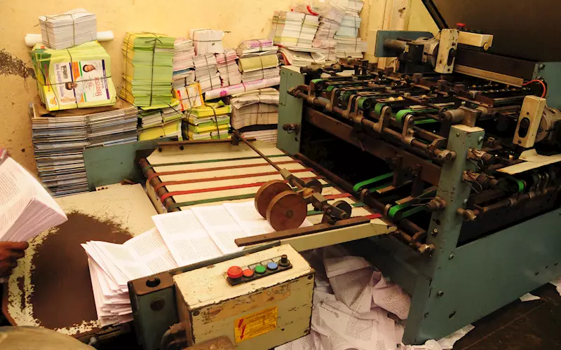 Printed sheets being folded to signatures on a folding machine