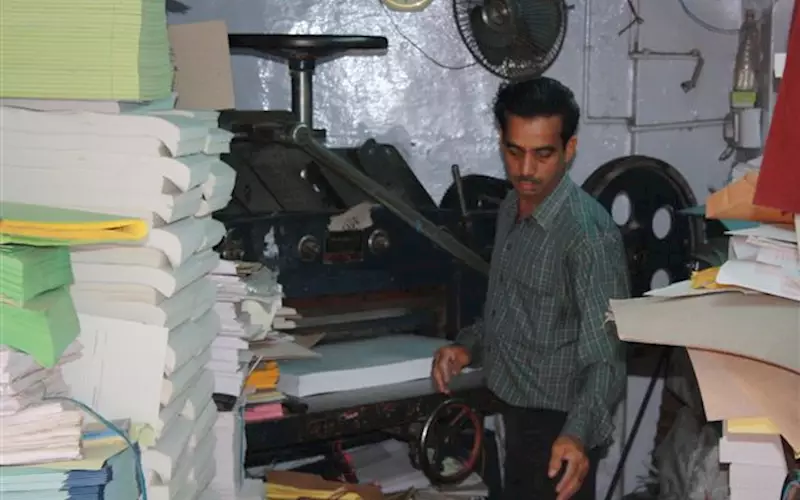 An operator working on a paper cutting machine