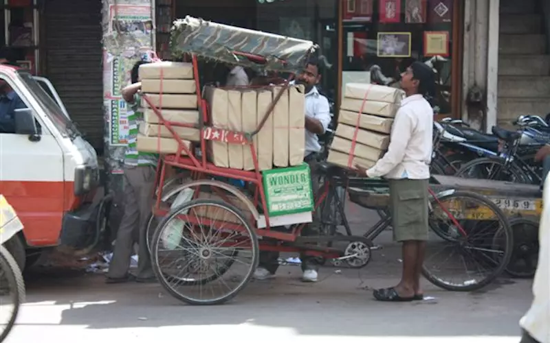 The paper market serves wholesale and retail customers. One such retail customers is arranging his stock on a hand rickshaw after having struck a good bargain