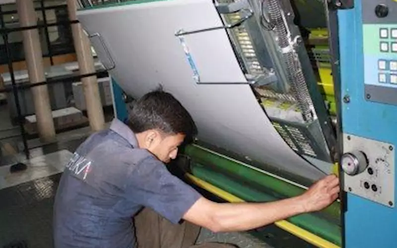 A printing press operator mounts the CTP plate on the press