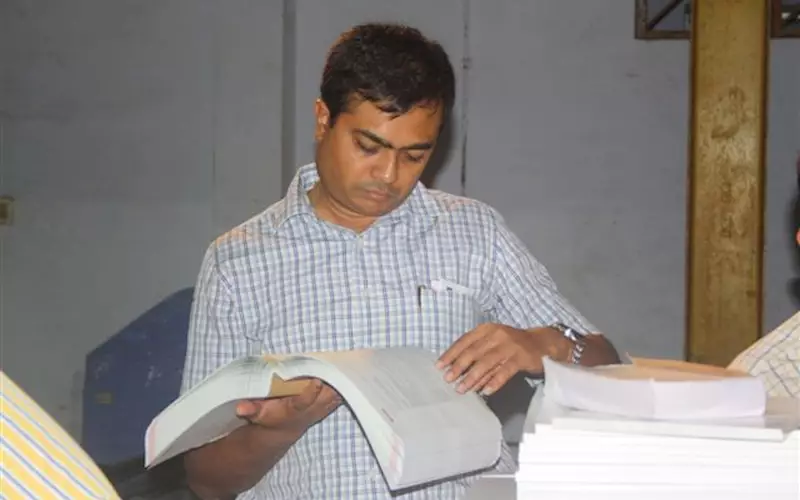 Mandar Ugar of Pune-based Vikram Printers scrutinises the lay flatness of a PUR-bound book sample