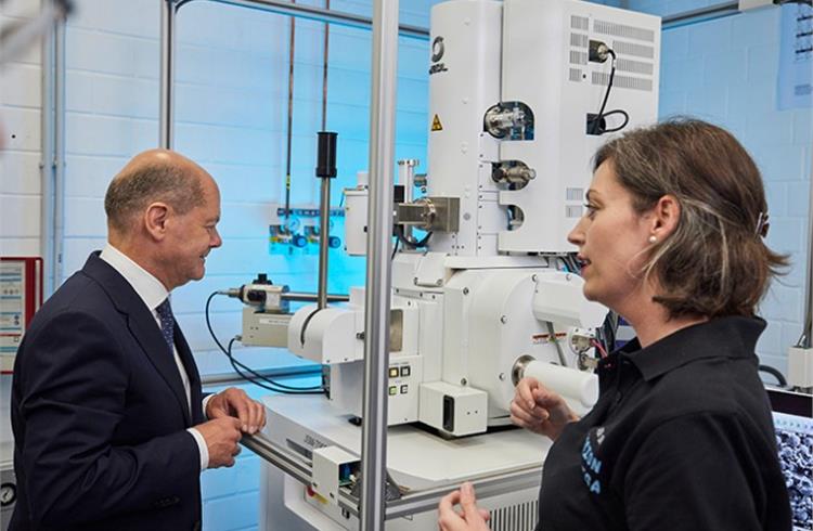 Laboratory employee Yvonne Lippert explains the scanning electron microscope (SEM) to German Chancellor Olaf Scholz..