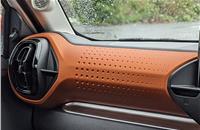 Stylish interior layout with split AC vent design, orange inserts on dashboard.