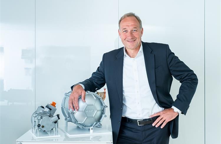 Mahle CEO Arnd Franz with two products for e-mobility: the e-compressor (left) and the MCT electric motor.