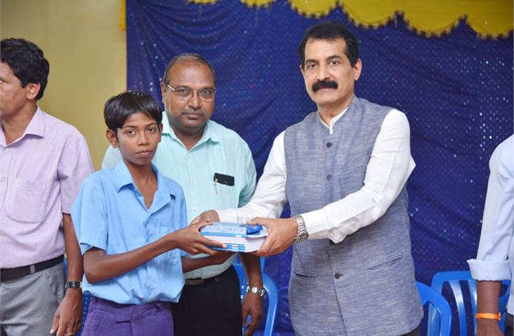 K V Rajendra Hegde, GM, TKM, hands over books and bags to students. Also seen are Gangemare Gowda, deputy director of Public Instruction and Marilinge Gowda, Block Education Officer, Ramanagara.