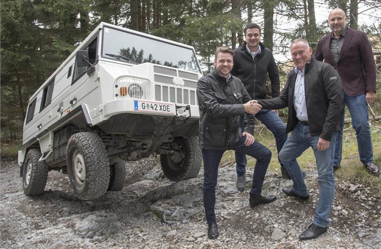 Ineos Automotive boss Dirk Heilmann (front left) shakes hands with Magna vice-president Helmut Gasser next to a Steyr-Daimler-Puch Pinzgauer 4x4