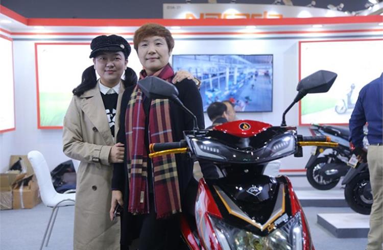Lana Zou, Chief Operating Officer, Dao EVTech (on the right) with the e-scooters displayed at the EV Expo in New Delhi.