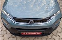 Tata's humanity line gloss-black grille flanked by sleek LED DRLs with halogen projector headlamps placed in bumper below.