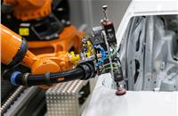 Robots sand the car body, apply the polishing compound, polish, change the attachments and switch out the sandpaper. Cameras track the scenario.