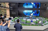 Hyundai Motor employees view a miniature model of smart mobility solutions, including UAM, PBV and Hub, for a dynamic human-centered future city concept, displayed in the first-floor lobby of its headquarters.