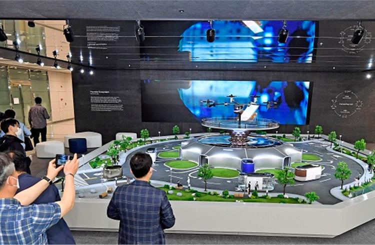 Hyundai Motor employees view a miniature model of smart mobility solutions, including UAM, PBV and Hub, for a dynamic human-centered future city concept, displayed in the first-floor lobby of its headquarters.
