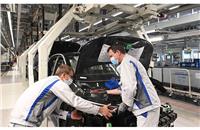 Two employees at Volkswagen plant in Zwickau install the headlight on the ID.3.