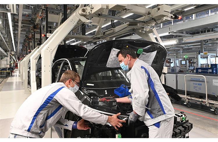 Two employees at Volkswagen plant in Zwickau install the headlight on the ID.3.