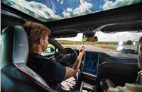 A test driver removes his hands from the steering wheel of a Tesla Motors Model S.