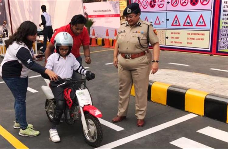 A child on the Honda CRF 50 training motorcycle along with Honda safety instructers and Delhi Police at IITF.