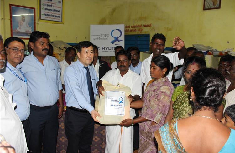 L-R:  Stephen Sudhakar J, VP (HR & GS) and Vinayagam G, oresident-UUHE look on as YK Koo, managing director, HMIL hands over relief materials to the flood affected villagers in Vengadu village in Srip