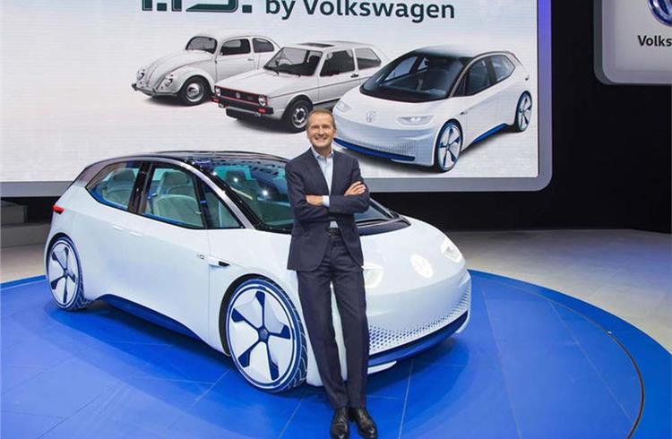 Herbert Diess standing in front of the VW ID hatchback