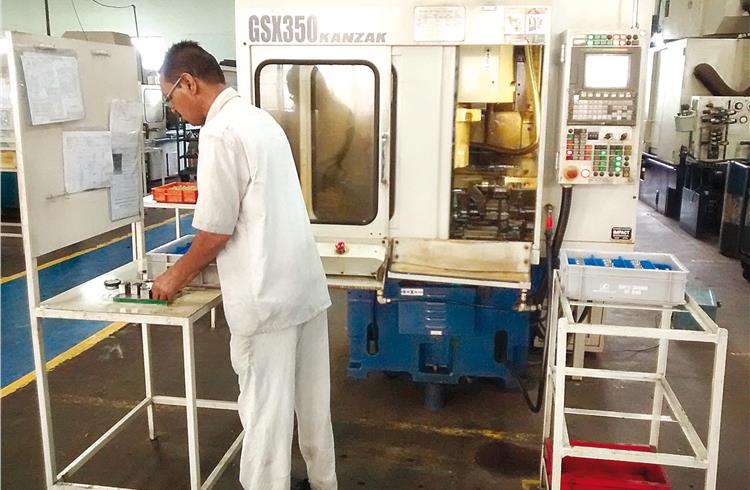 Operator using a Japanese CNC shaving machine for components made for Renault-Nissan.