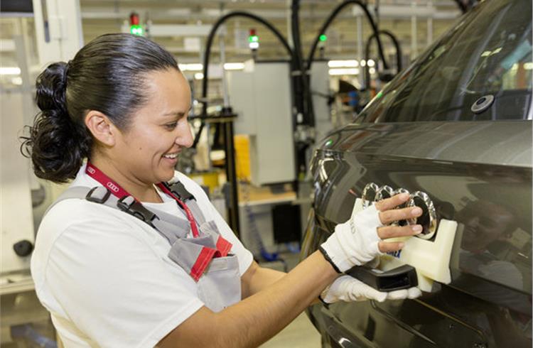 An employee in assembly at the Audi plant in San José Chiapa applies the Audi rings to the Q5