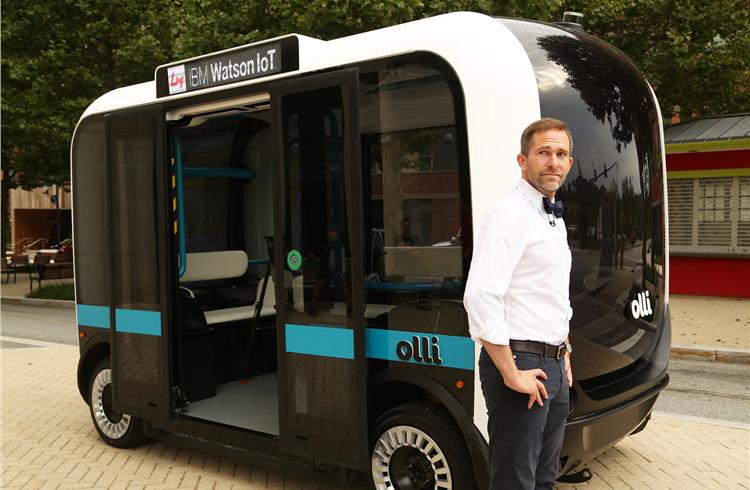 Local Motors CEO and co-founder John B. Rogers with Olli, the first self-driving vehicle to integrate the advanced cognitive computing capabilities of IBM Watson IoT. The 12-passenger EV analyses and 