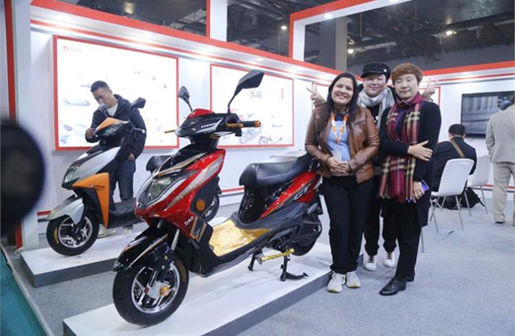 Lana Zou, Chief Operating Officer, Dao EVTech (on the right) and her team with the e-scooters displayed at the EV Expo in New Delhi.