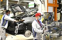 Two employees at Volkswagen in Zwickau install the front end on the ID.3.