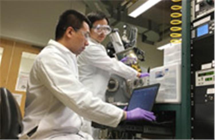 Qiang Li, a doctoral student and member of the research team, makes a deposition program on the operational computer, and Yifan Zhang, a professor in Purdue’s School of Materials Engineering, loads sa