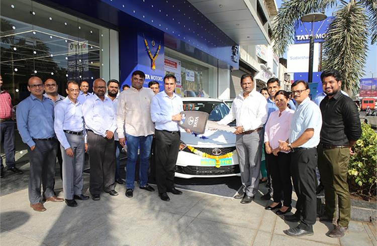 Tata Motors representatives handing over the Tata Tigor EV key to senior management of Aaron Travels at Sudarshan Motors dealership, Kalyan, Mumbai.