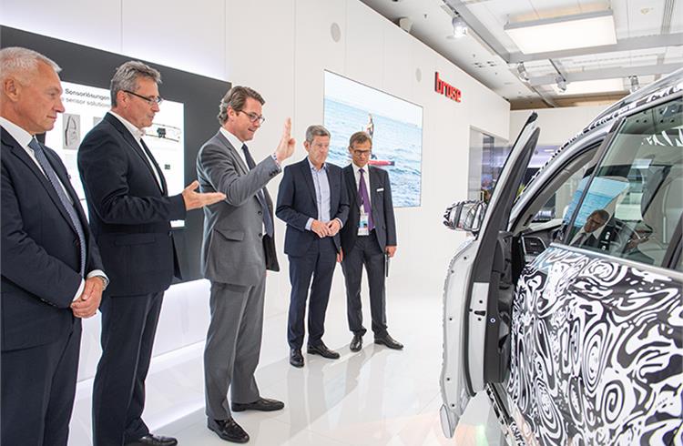 German Minister of Transport Andreas Scheuer (centre) opens the driver door of the Brose Concept Car with a hand gesture. 