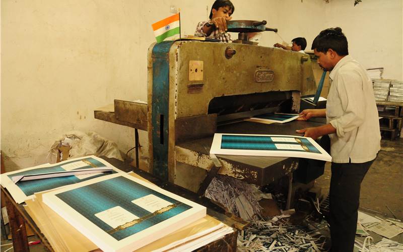 The manual process of cutting the printed sheets