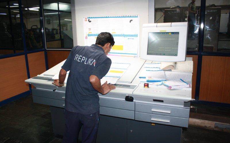 The operator checks the first few sheets for printing quality and registration faults